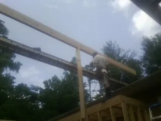Carpenter setting a ridge beam over a new addition frame — Ice Dam Removal by Roofing Brothers in Brownsdale