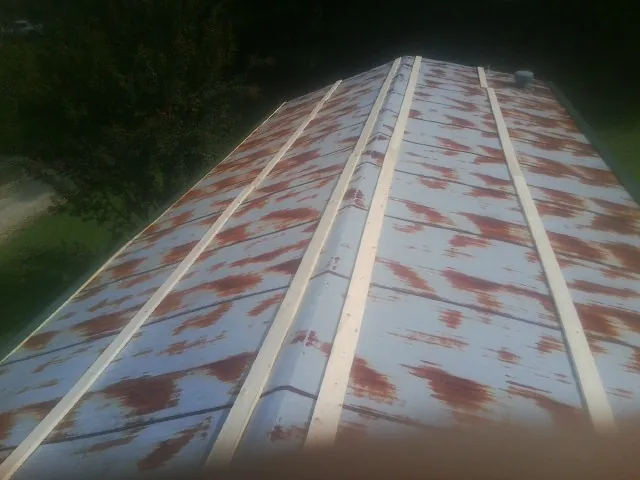 Rusted metal roof panels with new wood purlins before replacement — Storm Damage Roof Repair in Brownsdale by Roofing Brothers