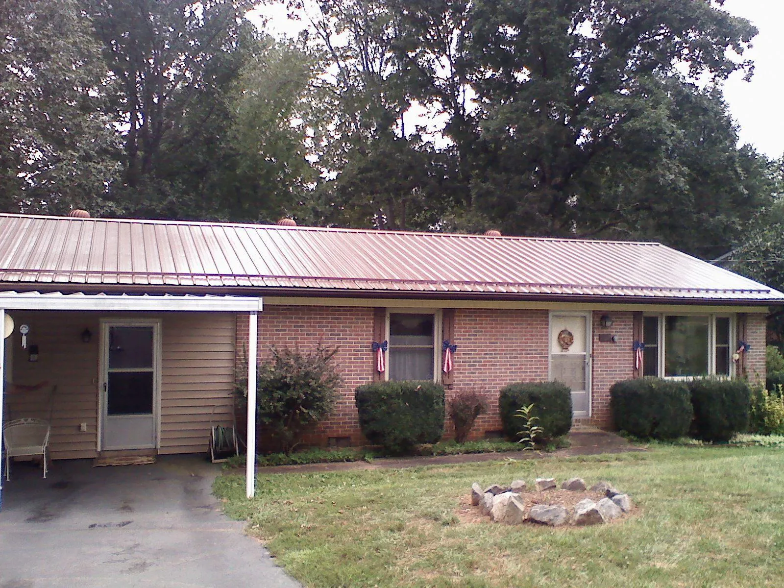 Bronze metal roof and carport on a brick ranch home — Roof Repair work by our crew in Brownsdale